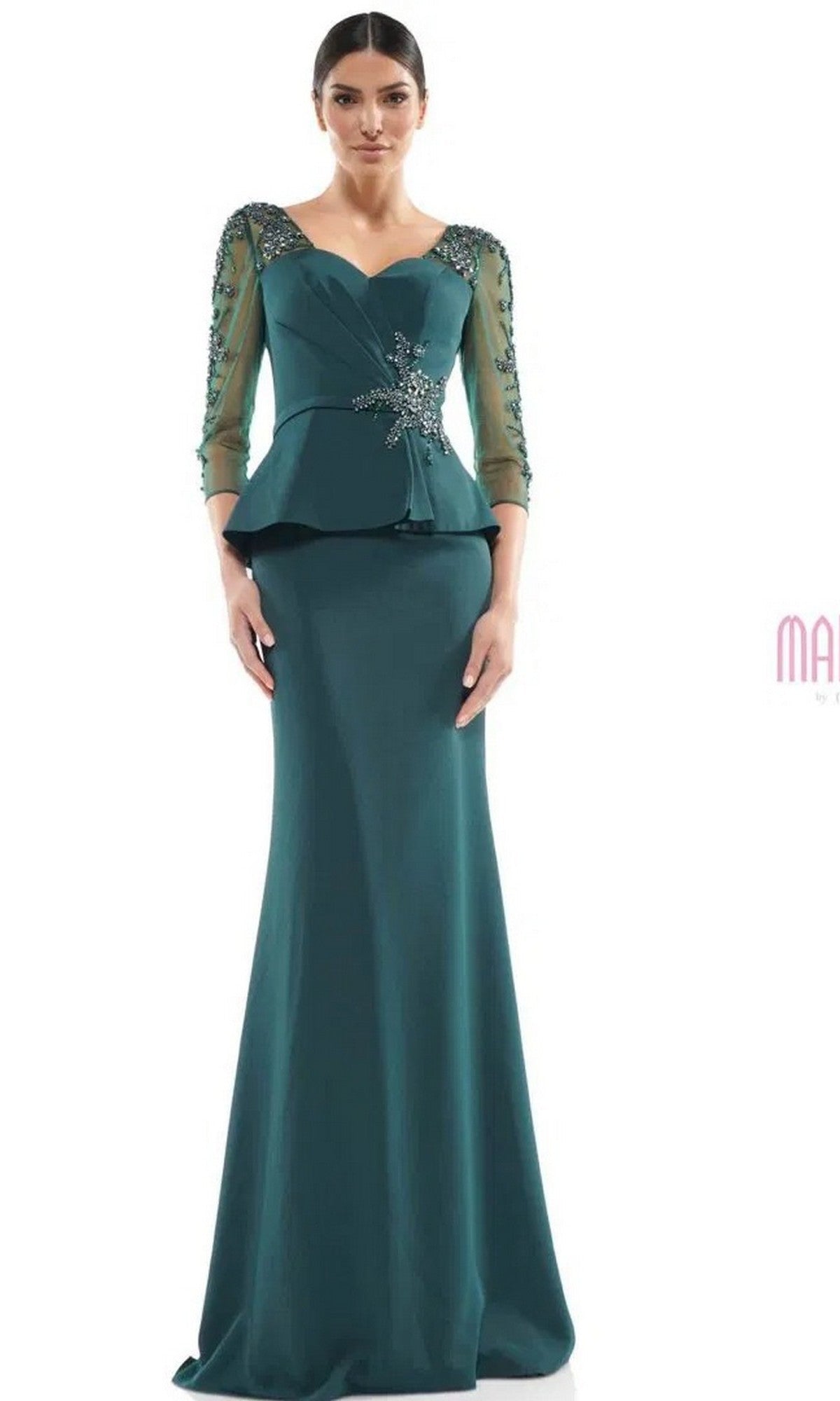 A woman models the Marsoni MV1037 long formal dress in deep green, featuring sheer beaded sleeves, a peplum waist, and decorative bodice embellishments, set against a plain white background.